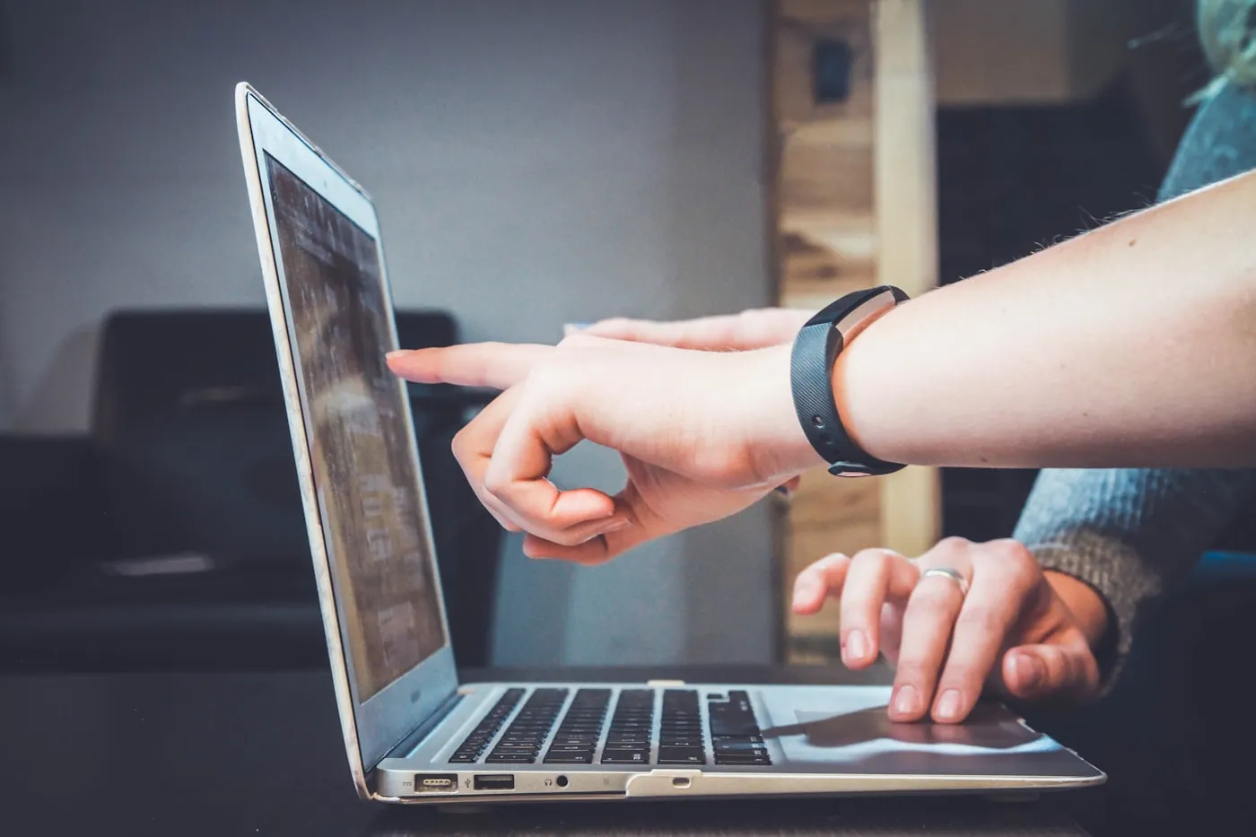 Personne pointant l'écran d'un ordinateur portable, gros plan sur les mains